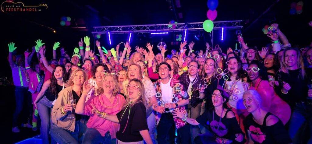 FEEST Bingo 4 1100x508 - Kamer van Feesthandel Bezoekers genieten van een interactieve feest bingo met dansende gasten, kleurrijke verlichting en populaire muziek