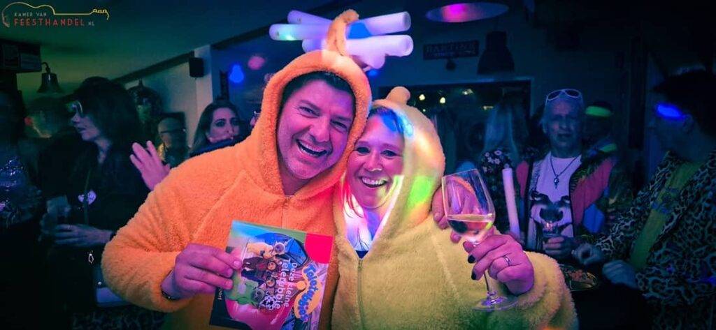 Bezoekers zingen en lachen tijdens een foute hits bingo avond vol guilty pleasures, feestverlichting en vrolijke chaos
