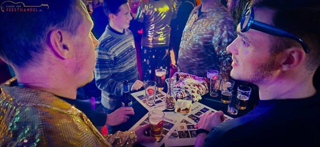 Gezellige foute kerstbingo met meezingende gasten, kerstdecoratie en een vrolijke kerstsfeer vol guilty pleasures
