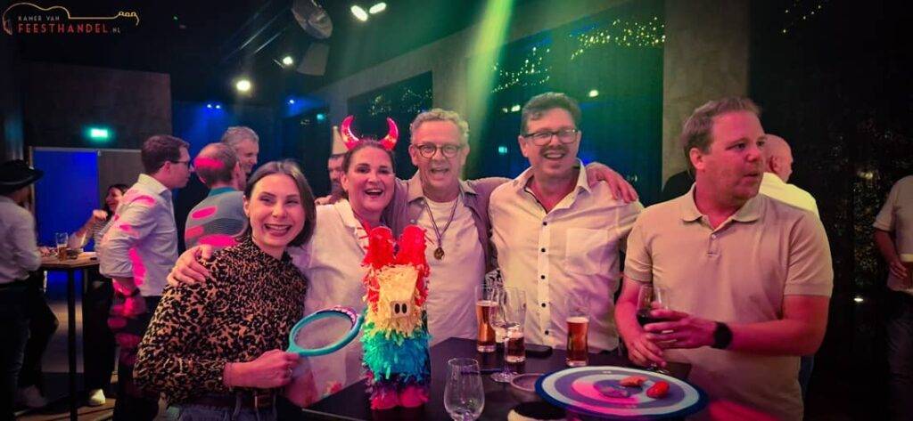 Muziekbingo tijdens bedrijfsfeest, met collega’s die samen lachen en meezingen terwijl de presentator en dj de avond professioneel begeleiden in een ongedwongen, feestelijke sfeer.